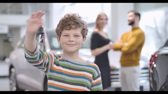 Cute Caucasian Boy with Curly Hair Showing Car Keys and Thumb Up