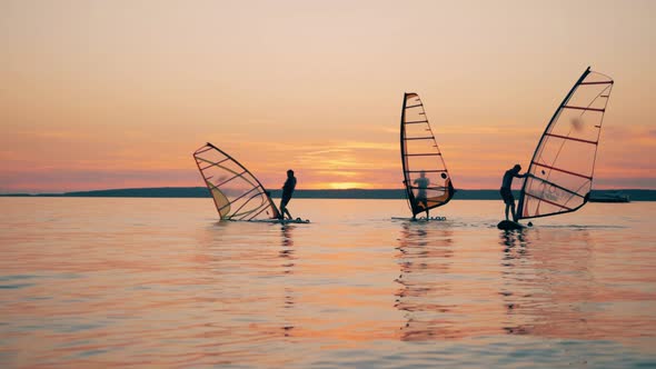 Group of Men on Sailboards with One of Them Falling