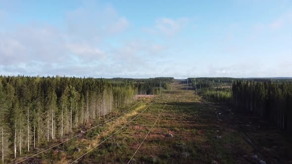 Drone shot flying over fields and forests with telephone lines in Finland