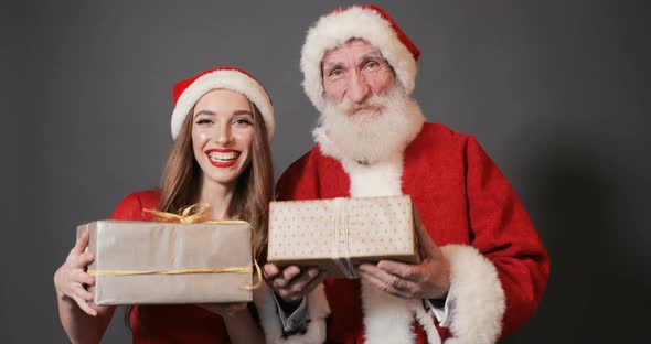 Santa Claus and Female Helper Give Presents