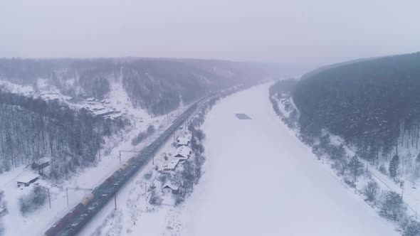 Two Freight Trains and Frozen River. Winter Landscape. Aerial View
