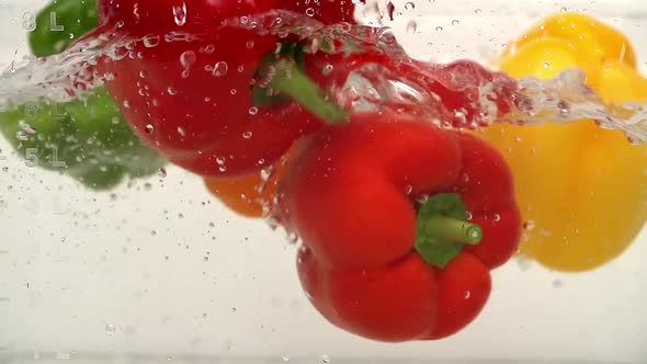 Ripe Peppers Falling Through Water