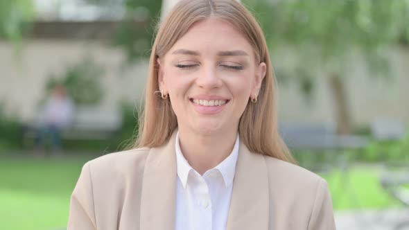 Outdoor Portrait of Young Businesswoman Shaking Head As Yes Sign