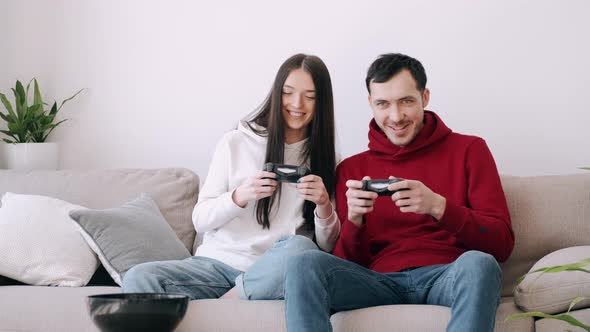 A Pretty Girl and a Boy Are Playing Video Games in the Living Room