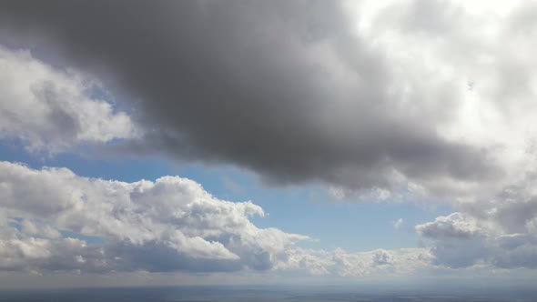 Aerial View at High Altitude of Dark Cumulus Clouds Forming Before Rainstorm