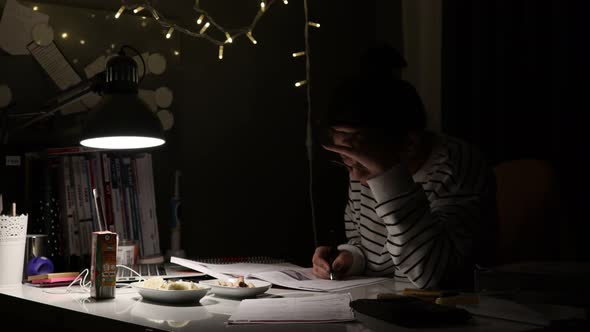 Student studying for the exam at the desk. With computer and textbooks. Time lapse. Close-up focus.