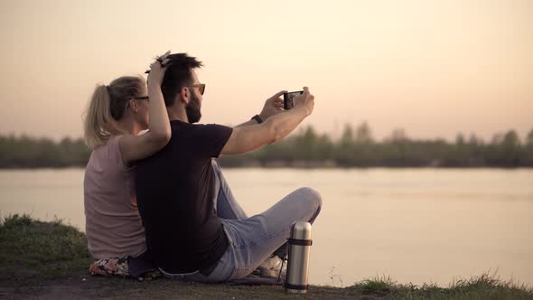 Boy And Girl On Holidays Vacation On Romantic Summer Evening. Loving Couple Taking Selfie On Mobile.