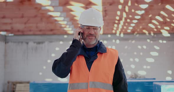 Costruction Worker Talking on Mobile at Construction Site