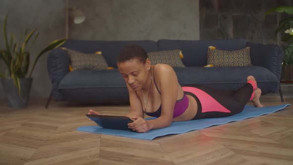 Female Searching Online Fitness Course on Tablet Pc