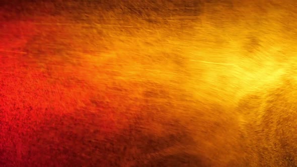 Red and Yellow Water Spray Mixed on a Black Background. Slow Motion alt