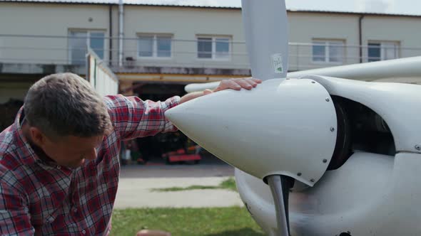 Aviator Fixing Airplane Propeller Smiling Enjoying Preflight Process Close Up