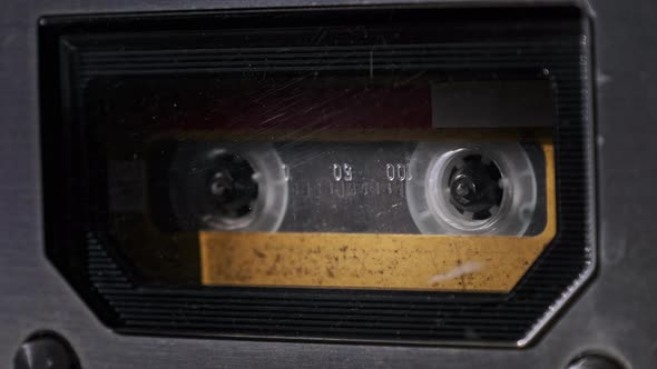 Vintage Yellow Audio Cassette Tape Rotates in Deck of an Old Tape Recorder