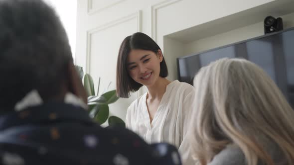 Slow motion of Chinese businesswoman smiling in creative business meeting with female colleagues