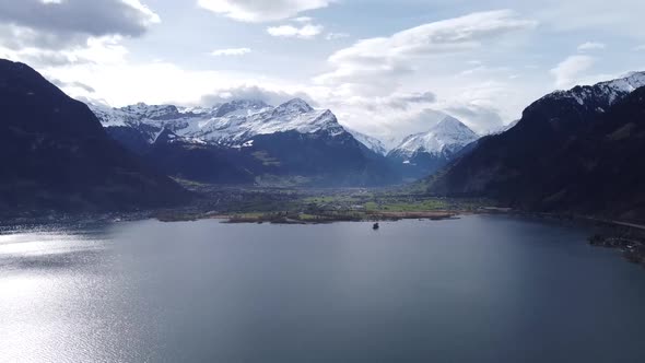 Snow-capped mountains with the famous Bristen summit, thrones over the deep blue Uri Lake, drone sho