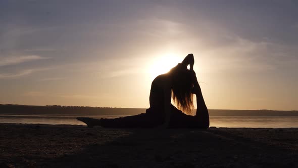 Young Pretty Woman Wearing Yoga Sportswear Working Out Against Sea Doing Yoga or Pilates Exercise