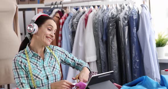 Seamstress Designer Stylist Cuts Fabric at Workplace in Atelier