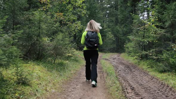 Woman tourist walking through the forest