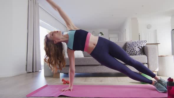 Woman performing exercise at home and recording it with digital camera