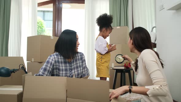 LGBT Family Unpacking Boxes In New Home On Moving Day.