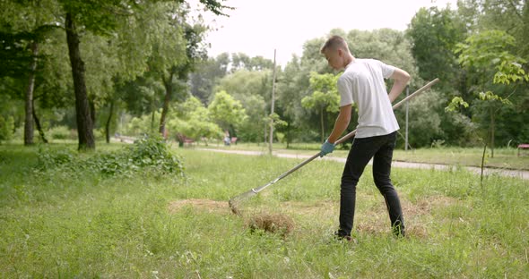 Boy Volunteer Picks Up a Trash in a Park