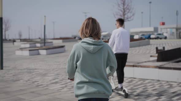 A Man and a Woman Ride an Electric Scooter