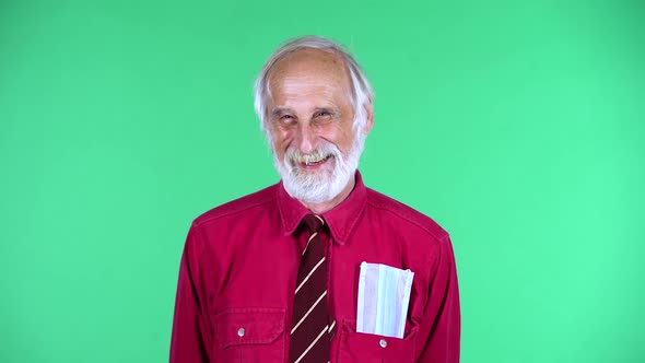 Portrait of Happy Old Aged Man 70s Looking at Camera with Sincere Kind Smile, Isolated Over Green
