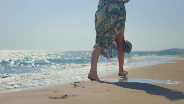 Woman legs walking in wet sand