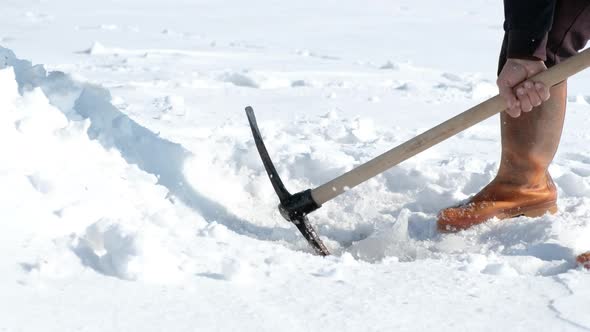 Fisherman Digs the Frozen Lake