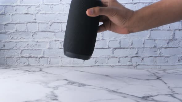 Man's Hand Using Smart Speaker on Table 