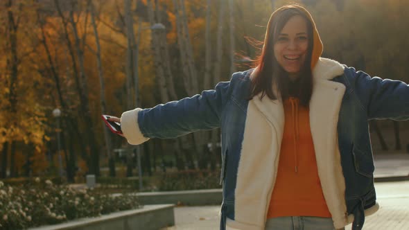 Young Woman Laughs Looking at Camera in City Park