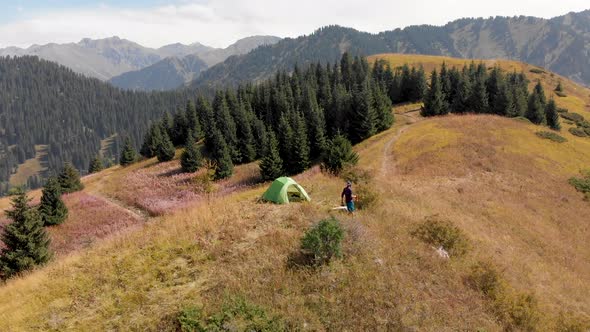 Tourist Near Green Camping Tent in the Mountain Forest