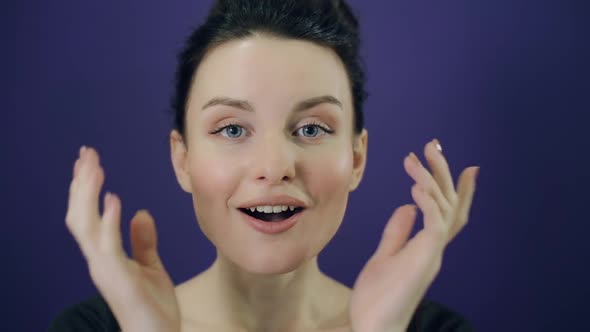 Surprised Young Woman on Purple Background