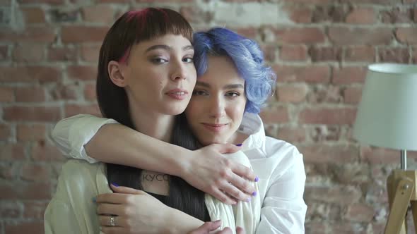 Young Womans in Friendship Hugging and Looking at Camera Posing Smiling
