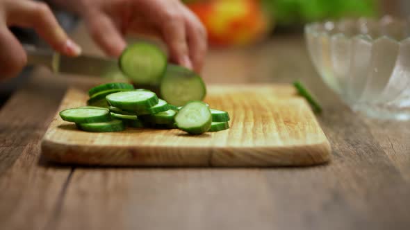 a man cuts cucumbers. cooking process by the chef. salad ingredients. a man prepares dinner