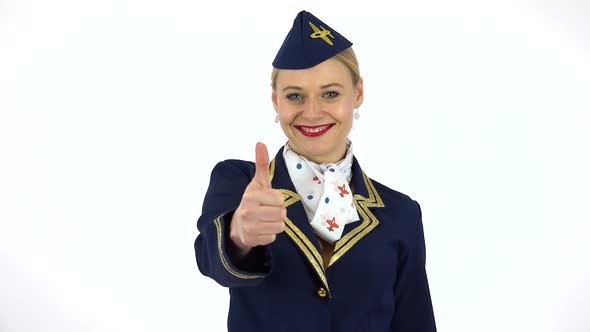 A Young Beautiful Stewardess Smiles and Shows a Thumb Up To the Camera - White Screen Studio