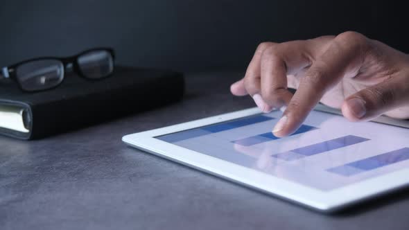 Close Up of Man Hand Analyzing Financial Charts on Digital Tablet 