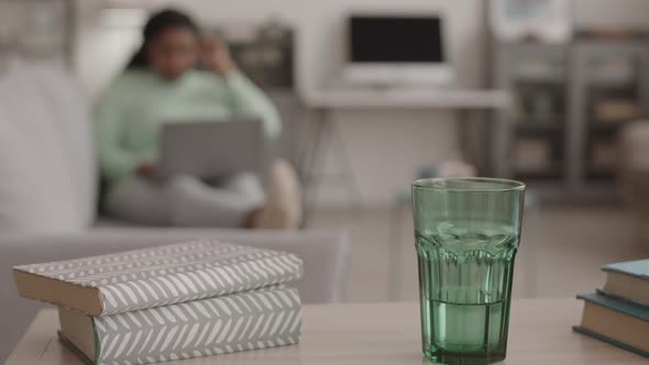 Glass and Books Lying on Desk in Living Room