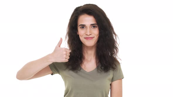 Portrait of Charming Curly Long Haired Woman Happily Showing Thumb Up on Camera Isolated on White