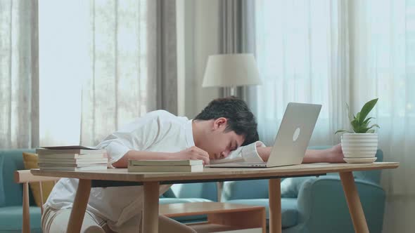 Asian Man Student Sleeping While Using Computer To Study Online At Home