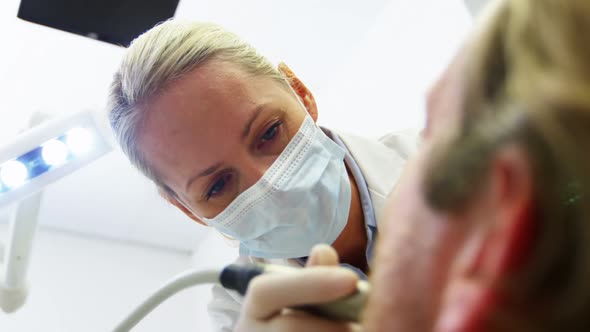 Dentist examining a patient with tools