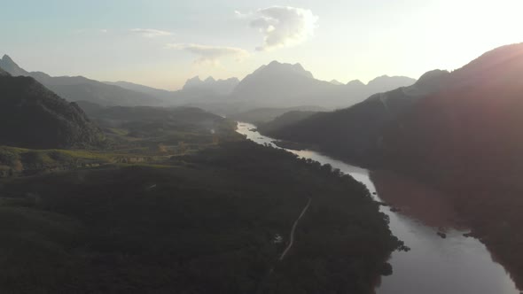 Aerial: flying over Nam Ou River Nong Khiaw Muang Ngoi Laos, sunset mountain landscape