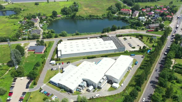 Moving Aerial Side Shot of Industrial Warehouse Loading Dock where Many Truck with Semi Trailers Loa