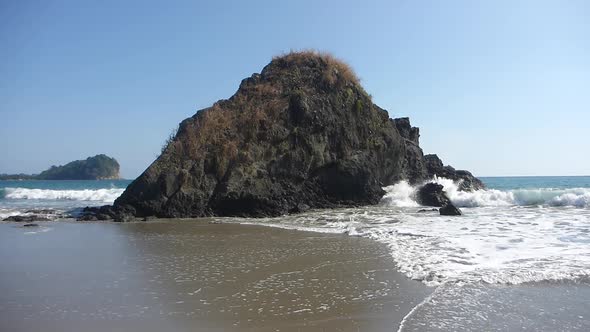 Costa Rica Pacific Ocean Slow Motion Waves around a shore Outcropping