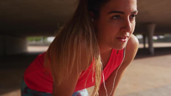 Caucasian woman working out under a bridge