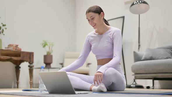 Latin Woman Talking on Video Call on Laptop on Yoga Mat