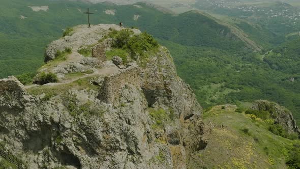 Majestic scenery of the Azeula Fortress and a cross against a broad wilderness.