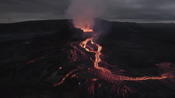 Aerial view overlooking lava rivers at a volcano basin - circling, drone shot