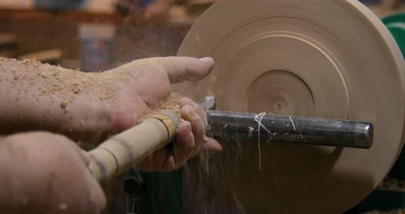 Closeup of carpenter turning wood on a lathe