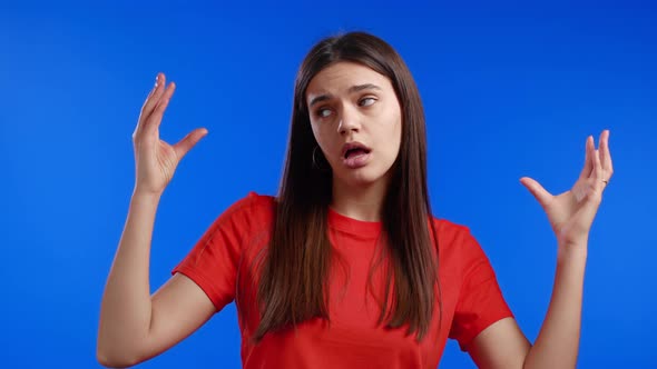 Pretty Woman Showing Blablabla Gesture with Hands and Rolling Eyes Isolated on Blue Background