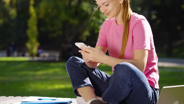 Female Using Smartphone Texting Message and Laughing